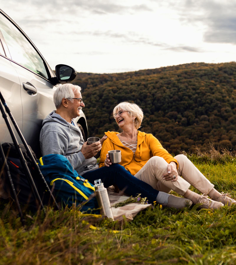 couple taking a break next to their car on a hike talking about tax deferred annuity