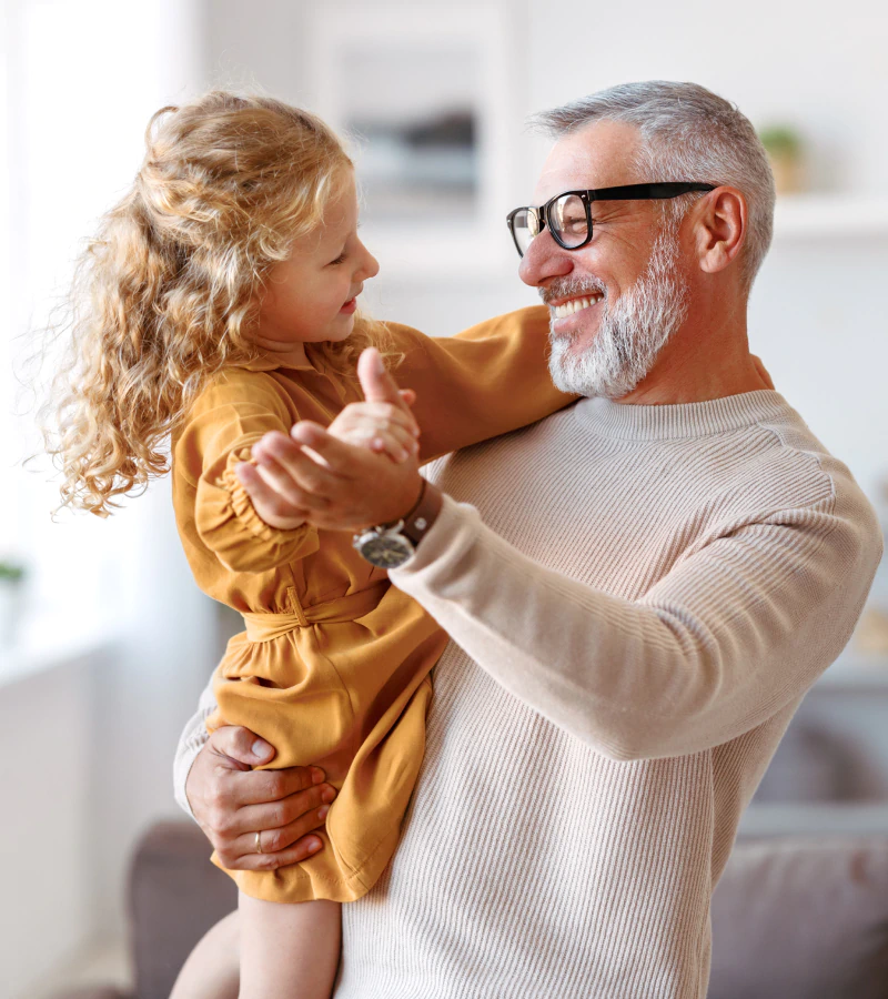 grandfather dancing with young granddaughter