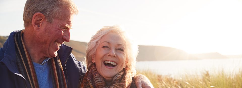 laughing elder couple under sunshine at beach annuity basics beacon financial williston vt