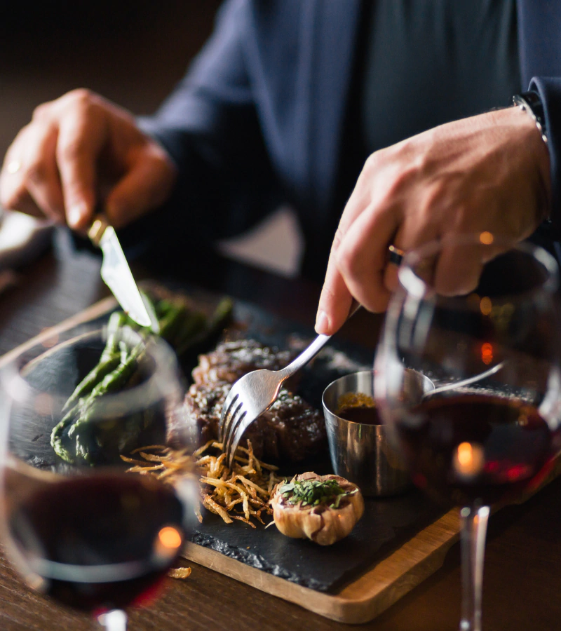 man cutting steak dinner